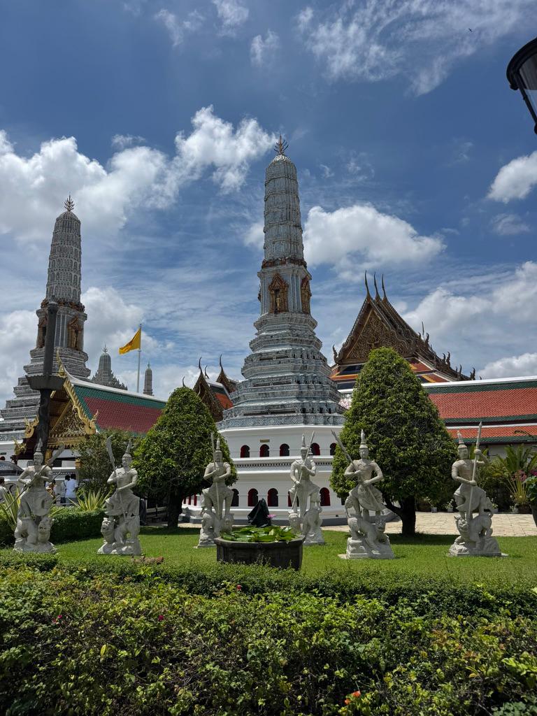 White prangs and guardian statues on the Grand Palace grounds.