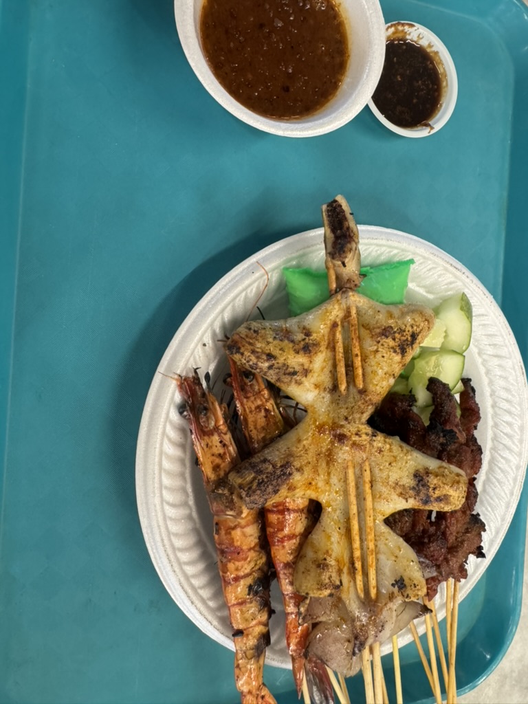 Grilled squid, prawns, and satay with peanut sauce at Lau Pa Sat, Singapore.