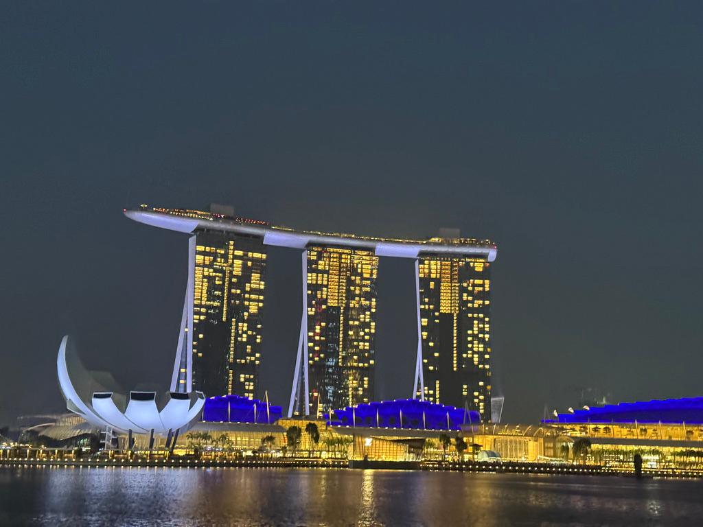 Marina Bay Sands and the ArtScience Museum at night, seen from the water.