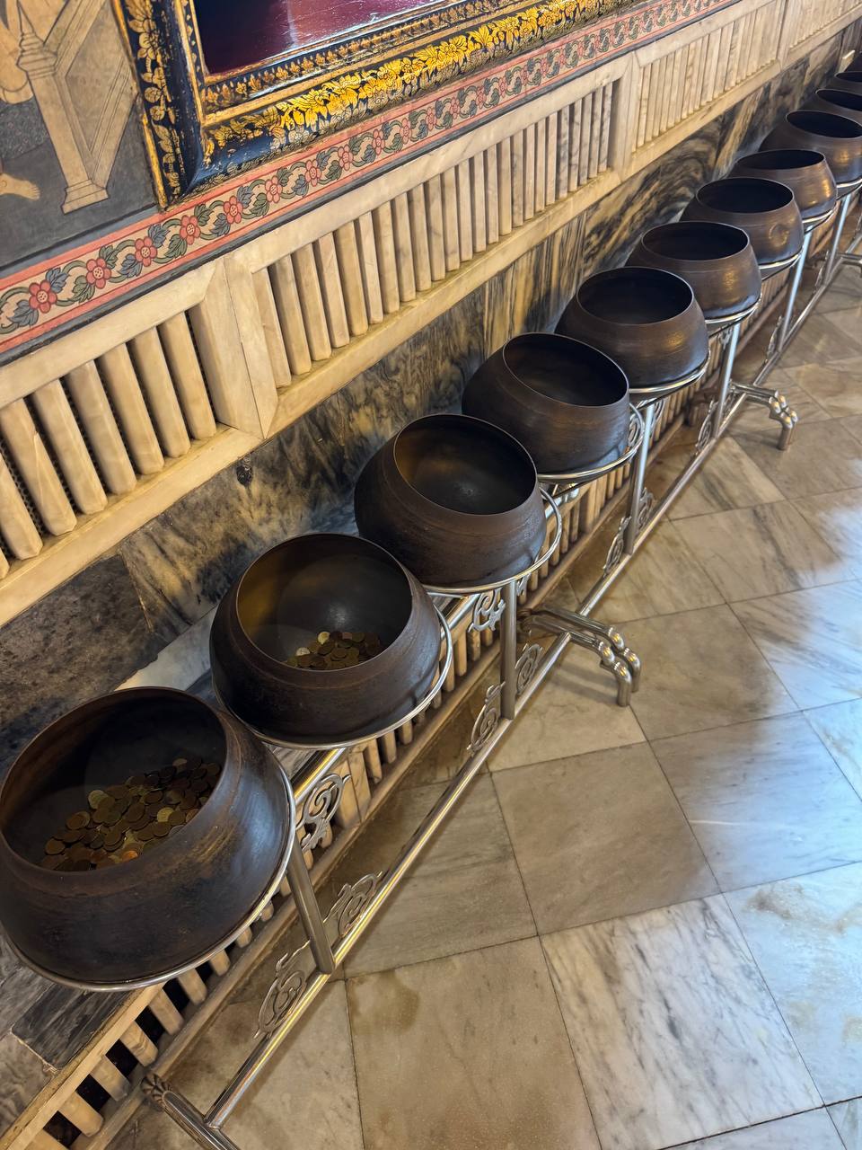 The row of bowls for the coin ritual at Wat Pho.